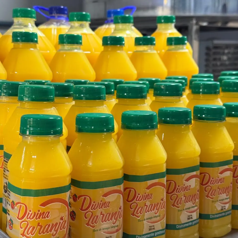 Estoque de garrafas de suco integral Divina Laranja na produção local